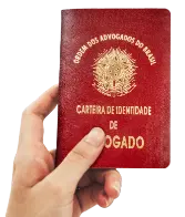 mão segurando carteira de identidade de advogado da oab